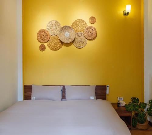 a bedroom with a white bed with a yellow wall at Rail & Rest Homestay - Railway View in Hanoi
