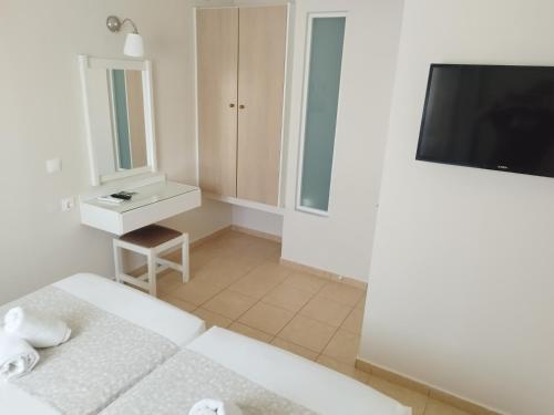 a small bedroom with a bed and a television at Blue Sky Apartments in Malia