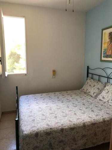 a bedroom with a bed and a window at La Punticeddha Apartment in SantʼAndrea