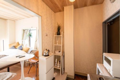 a bedroom with a bed and a desk and a table at Lazurite GUESTHOUSE Pear Field in Inagi