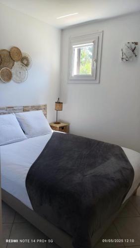 une chambre avec un lit avec une couverture noire dessus dans l'établissement F2 tout confort, les pieds dans l'eau, PORTICCIO, à Grosseto-Prugna