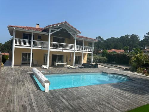 une maison avec piscine et une maison dans l'établissement VILLA Magnifique GOLF & OCEAN, à Lacanau