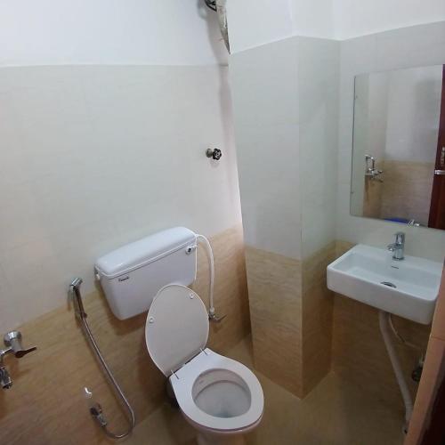 a bathroom with a toilet and a sink at Premier Guest House in Kolkata