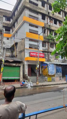 a man sitting on a bench in front of a building at Premier Guest House in Kolkata