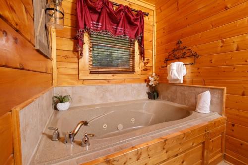 La salle de bains en bois est pourvue d'une grande baignoire. dans l'établissement Award Winning Views, à Sevierville