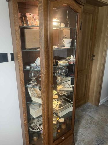 a wooden cabinet filled with dishes and wine glasses at Dom ARCHITEKTA 