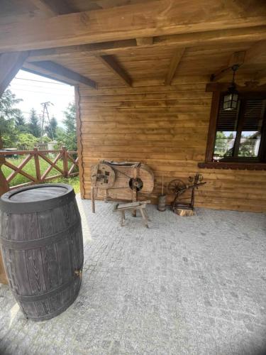 a wooden cabin with a barrel and a bench at Dom ARCHITEKTA 
