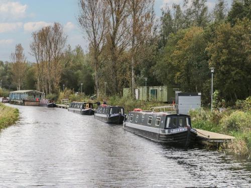 three boats are docked on a river at Ash in Denny