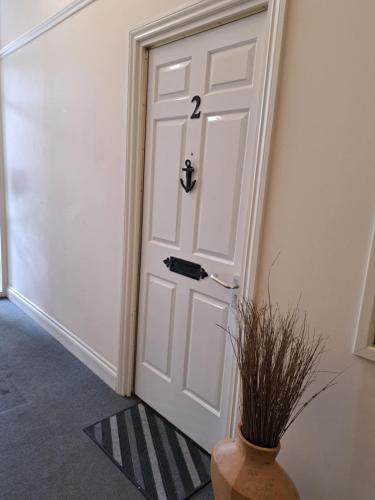 a white door with a vase next to it at Historic central apartment in Castlehill Mansions in Campbeltown