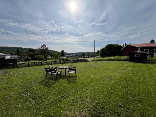 a picnic table and two benches in a yard at Villa Lugnvik in Lugnvik
