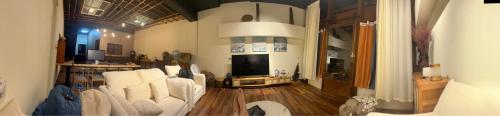 a living room with white chairs and a television at Lishan House in Heping