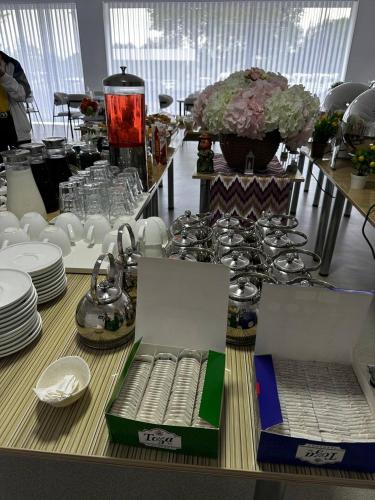 a table with plates and cups and a table with plates and glasses at BOG'DON GRAND Hotel in Tashkent