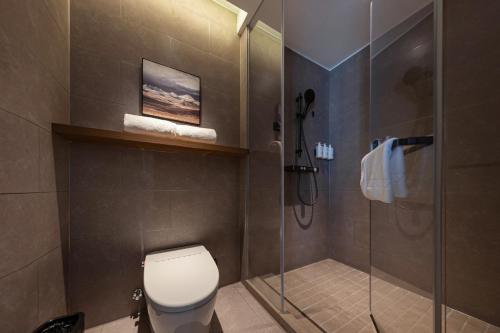 a bathroom with a toilet and a glass shower at Atour Hotel Xiamen Huli Powerlong International in Xiamen