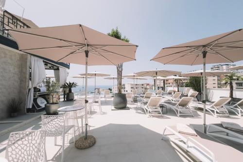 a patio with tables and chairs and umbrellas at Padam Hotel & SPA in Ulcinj