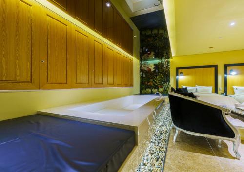 a large bathroom with a tub and a table and chairs at Hotel The Designers Incheon in Incheon