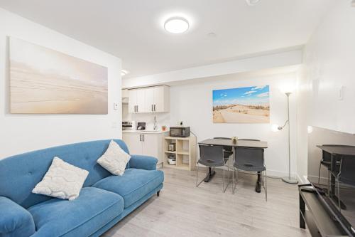 a living room with a blue couch and a kitchen at Dumfries Guest Room in Vancouver in Vancouver