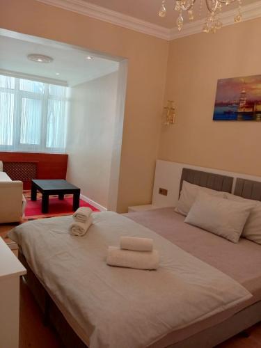 Un dormitorio con una cama grande con toallas. en Karina Apart Hotel, en Estambul
