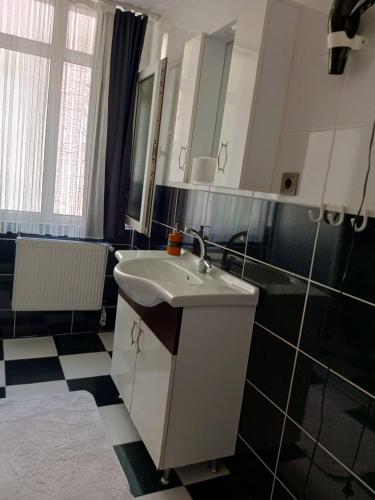 y baño con lavabo y azulejos blancos y negros. en Karina Apart Hotel, en Estambul