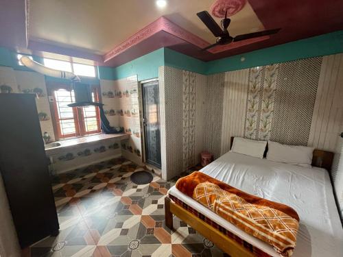 a bedroom with a bed and a ceiling fan at Eksringa Guest House in Guwahati