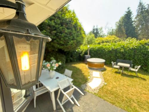 a backyard with a table and chairs and a lantern at Luxe Chalet Veluwe Private Hottub - Romantic Getaway - Veluwe in Voorthuizen