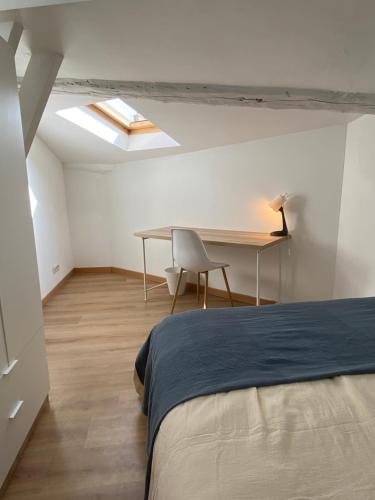 une chambre avec un lit, un bureau et une table dans l'établissement La Terrasse - Centre-ville proche gare, à Valence