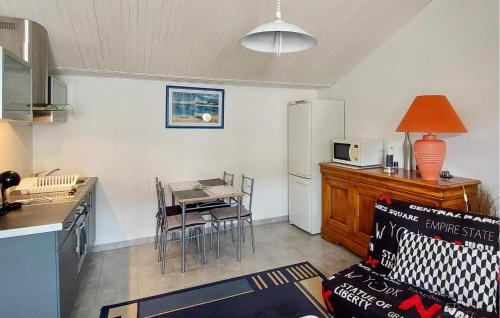 une petite cuisine avec une table et un réfrigérateur dans l'établissement Jolie Maison Neuve, à Casteljaloux