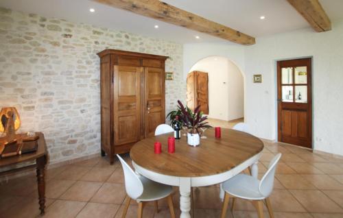 a dining room with a wooden table and white chairs at Stunning Home In St Montan 