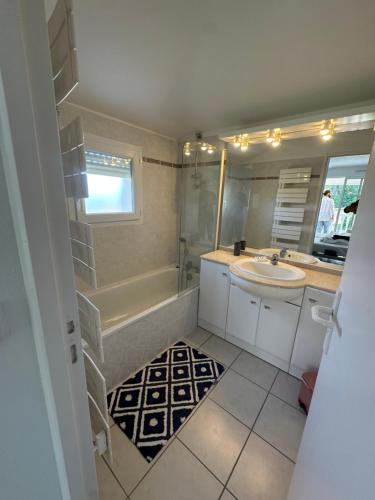 une salle de bain avec une baignoire, un lavabo et une douche dans l'établissement VILLA Magnifique GOLF & OCEAN, à Lacanau