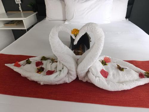 two swans towels are sitting on a bed at Shalakwe Hills-Inn Guesthouse Kasane in Kasane