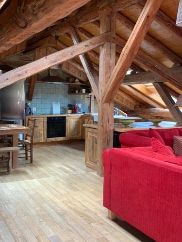un salon avec un canapé rouge et une cuisine dans l'établissement Chalet Tarine, à Bourg-Saint-Maurice