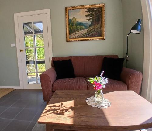 a living room with a couch and a table with flowers at Burra Hills in Burra