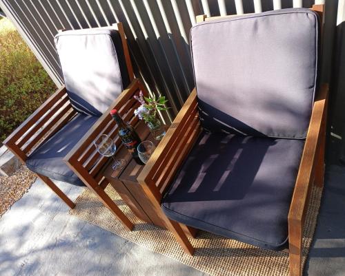 two chairs sitting on a porch with a bottle of wine at Burra Hills in Burra