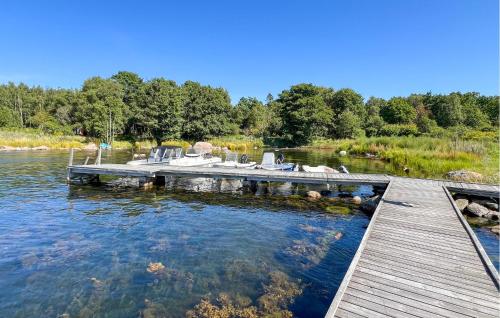 a dock on a lake with boats in the water at Awesome Home In Sturkö With Sauna in Sturkö