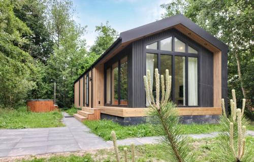 a small house with a black roof at 3 Bedroom Amazing Home In Oud Gastel in Oud-Gastel