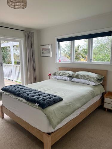 a bedroom with a large bed with a large window at Studio 35 Kerikeri in Kerikeri
