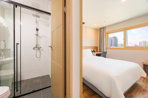 a hotel room with a bed and a shower at Hotel Moon in Jeju