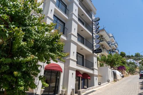 a white building with red awnings on a street at Brow City Kaş in Kas