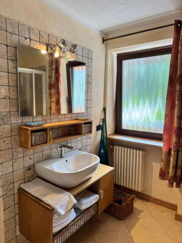 a bathroom with a sink and a mirror and a window at We are 4810 Chalet Les Crampons in Courmayeur