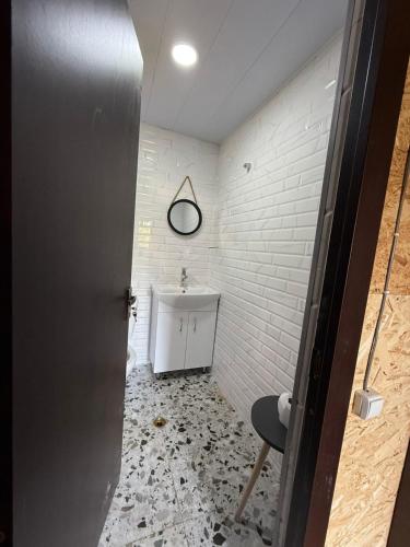 a bathroom with a sink and a door and a chair at Welcome to Tamara Cottage in Tba