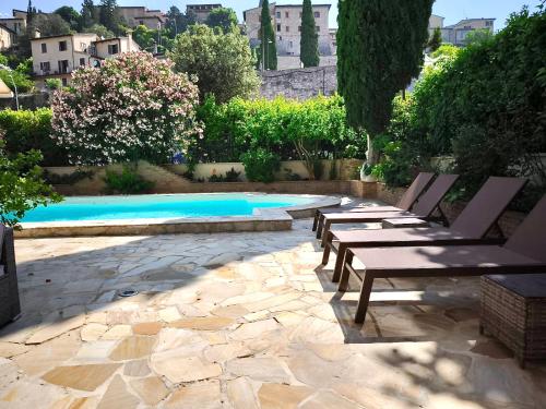 a patio with benches next to a swimming pool at Villamena in Spello