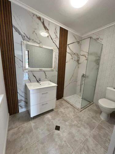a bathroom with a sink and a shower and a toilet at Horizont Apartments in Sunny Beach