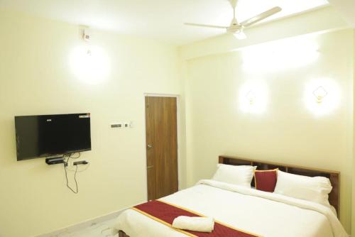 Un dormitorio con dos camas y un televisor de pantalla plana. en AK Residency, en Chennai