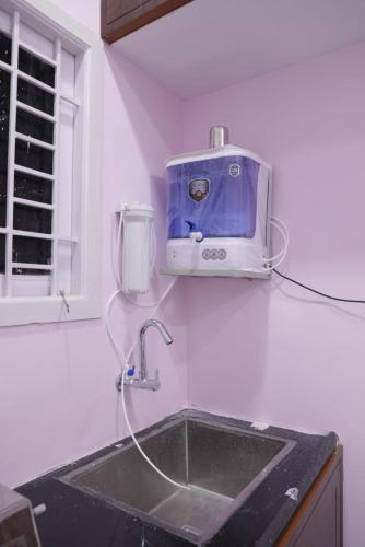a kitchen sink with a toaster on the wall at AK Residency in Chennai