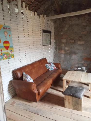 a brown leather couch in a room with a table at LES ANGES in Covelo