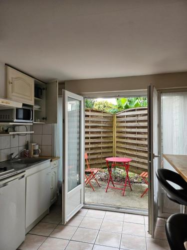 une cuisine avec une porte s'ouvrant sur une terrasse avec une table. dans l'établissement Studio, à Vic-en-Bigorre