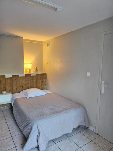 une chambre avec un grand lit dans une pièce dans l'établissement Studio, à Vic-en-Bigorre