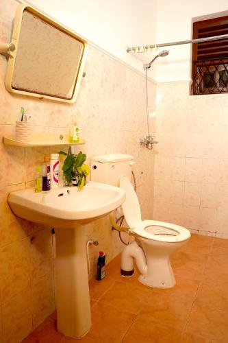 a bathroom with a toilet and a sink and a mirror at House of Sincerity in Maharagama