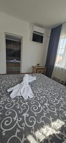a towel laying on top of a bed at Sîrbu Orsova in Orşova
