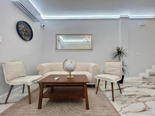 a living room with a couch and two chairs and a table at Dimora Santa Rosalia in Alba