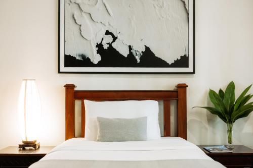 a bedroom with a bed and a picture on the wall at Athena Hotel in Pakse